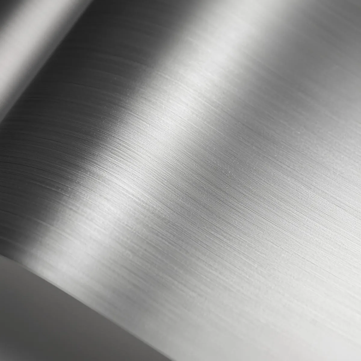 Close-up of brushed titanium foil curving away from the camera